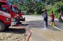 Petugas Damkar saat memberikan timbunan tanah yang kotori jalan Nori Nori, kabupaten Nias Selatan