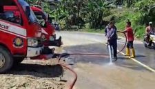Petugas Damkar saat memberikan timbunan tanah yang kotori jalan Nori Nori, kabupaten Nias Selatan