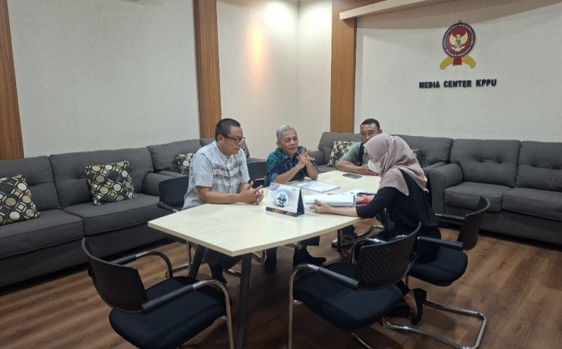 Iskandar menyerahkan sejumlah dokumen pengaduan kepada Komisi Pengawas Persaingan Usaha (KPPU)