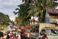 Proses evakuasi pelajar dan masyarakat yang akan melintasi genangan air oleh petugas gabungan
