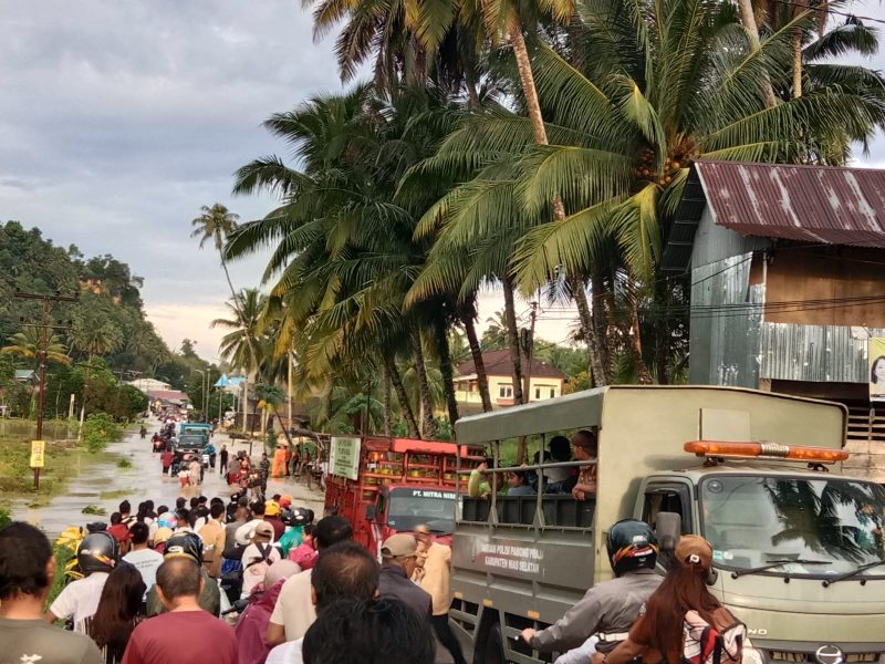 Proses evakuasi pelajar dan masyarakat yang akan melintasi genangan air oleh petugas gabungan
