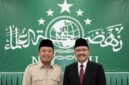 Nusron Wahid (kiri) dan Saefullah Yusuf (kanan) dengan latar belakang bendera / logo Nahdlatul Ulama (NU).