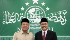 Nusron Wahid (kiri) dan Saefullah Yusuf (kanan) dengan latar belakang bendera / logo Nahdlatul Ulama (NU).