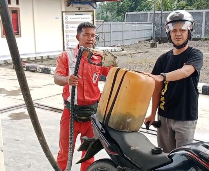 Nampak petugas SPBU melayani BBM subsidi dengan jerigen